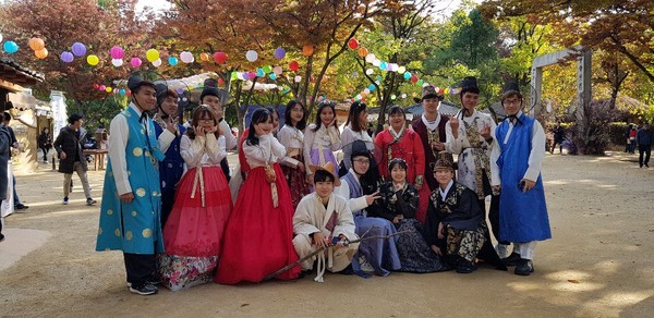 ▲ 한국민속촌에서 한복을 입고 기념촬영하는 신한대 유학생들.