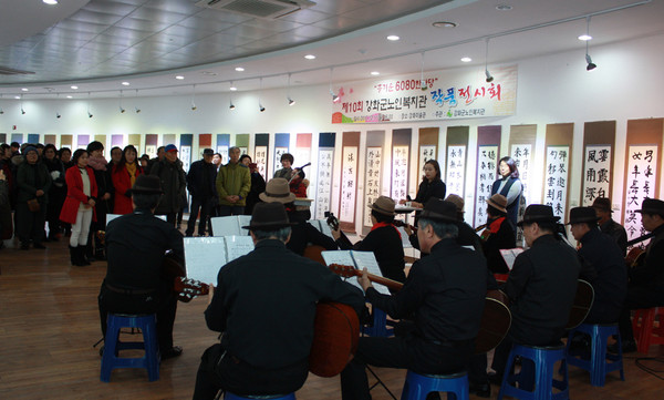 ▲ 작품 전시회에서 연주를 선뵈는 어르신들.