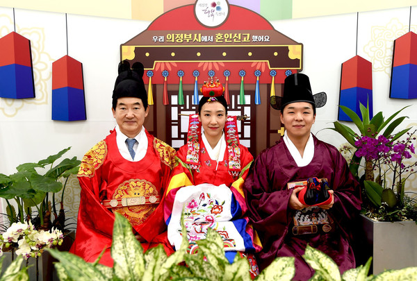 ▲ 신혼부부와 혼인신고 인증샷을 찍는 안병용 의정부시장(왼쪽).