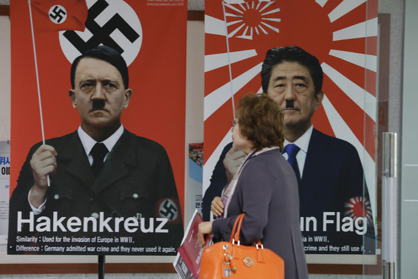▲ 복도에 걸린 나치의 상징 깃발의 히틀러와 전범 상징인 욱일기의 일본 아베 총리 포스터.