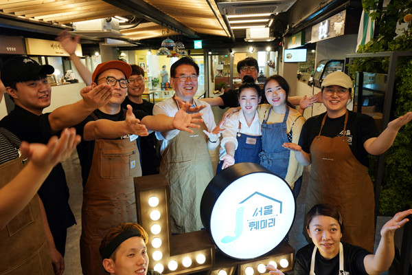 ▼ 경동시장 청년몰 서울훼미리에서 구청장과 청년 상인들이 기념촬영을 하고 있다.