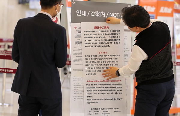 ▲ 운행 중단 안내문 붙이는 일본항공사 직원들.