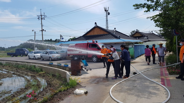 ▲ 주민들에게 소방호스 사용법 교육하는 소방대원들.