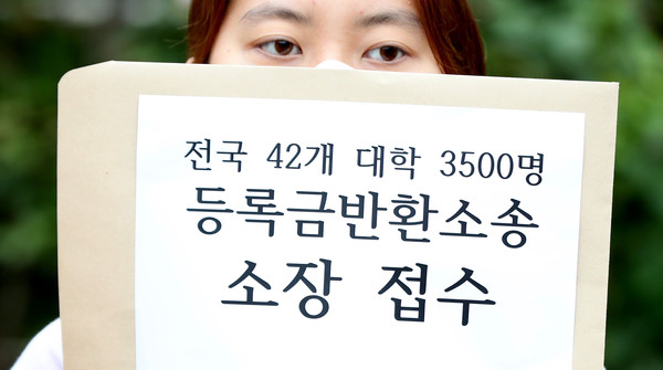 ▲ 등록금 반환 집단 소송 기자회견에서 소장 접수 서류를 들고 있는 등록금반환본부 소속 대학생.