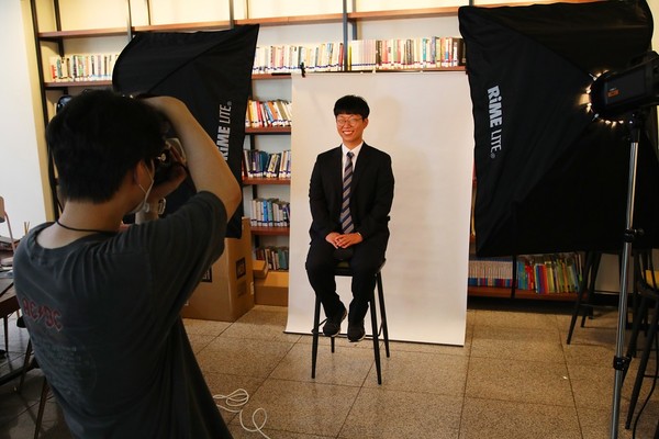 ▲ 한국장학재단 본사 북카페에 차려진 ‘청년사진관: 웃는 내.일.’에서 대구시 청년 프리잡(pre-job) 사업에 참여했던 청년이 취업용 사진을 쵤영하고 있다.