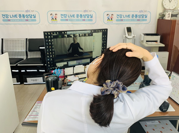 온라인 1:1 홈처방 운동상담실 참여자가 화상 프로그램을 통해 올바른 운동법을 배우며 스트레칭을 하고 있다.