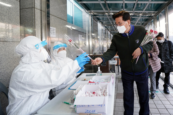 ▲ 유덕열 동대문구청장이 지난 8일 세계 여성의 날을 맞아 동대문구보건소 선별진료소에서 근무 중인 여성 의료진에게 장미를 건네고 있다.