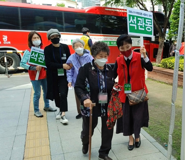 ▲ 석관동 통장 김희자 씨가 백신접종을 위해 예방접종센터로 이동하는 어르신들을 안내하고 있다.