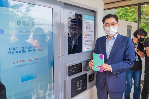 ▲ 지난 8일 개관한 3호점에서 무인도서대출 서비스를 이용하고 있는 이정훈 강동구청장.