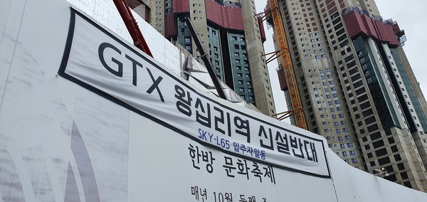 ▲ 동대문구 청량리역 일대 공사가 진행중인 롯데캐슬 스카이 L-65 안전펜스에 걸린 ‘GTX 왕십리역 신설반대’ 현수막. /뉴시스