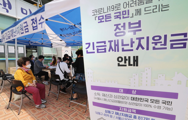 ▲ 지난해 서울 성동구 금호2.3가동주민센터에서 시민들이 재난지원금 신청 접수를 하고 있다. /뉴시스