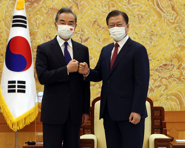 ▲ 주먹인사하는 문재인 대통령과 왕이 외교부장. /뉴시스