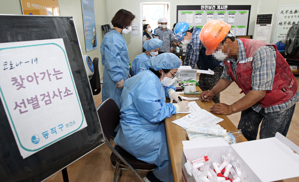 ▲ 동작구 보건소 관계자들이 지난달 30일 관내 근로자수 50인 이상 건설공사장을 대상으로 찾아가는 선별진료소를 추가 운영했다.
