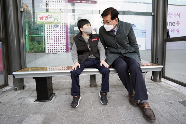 ▲ 온열의자 점검 중 버스를 기다리는 아이와 대화하는 유덕열 동대문구청장.