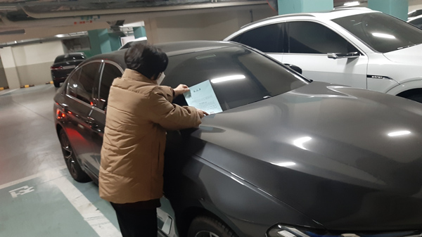 ▲ 성북구 관계자가 대상 차량에 계고장을 발부하는 모습.