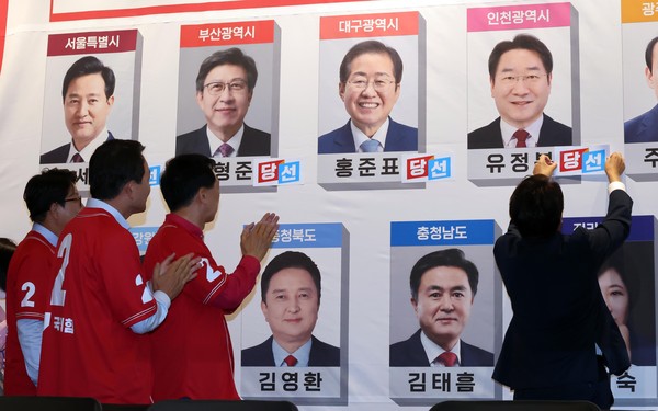 ▲ 당선확실 후보 사진에 스티커 붙이는 국민의힘. /뉴시스