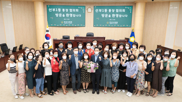 ▲ 선부1동 통장협의회 회원들이 27일 의회를 방문해 견학을 실시했다. 사진은 이날 본회의장에서 기념촬영에 임하고 있는 통장협의회 회원들과 의원들의 모습.