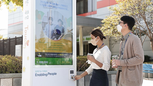 ▲ 삼성전자 직원이 수원사업장 내에 설치된 나눔키오스크에 사원증을 태깅해 기부에 참여하고 있다./뉴시스