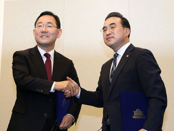 ▲ 주호영(왼쪽) 국민의힘 원내대표와 박홍근 더불어민주당 원내대표가 서울 여의도 국회에서 열린 기자회견에서 이태원 참사 진상규명을 위한 국정조사를 실시하기로 한 전격 합의문에 서명한 뒤 악수하고 있다. /뉴시스
