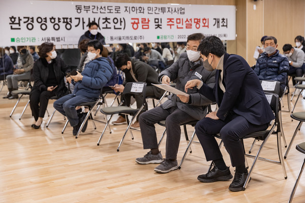 ▲ 군자동 주민센터에서 실시된 ‘동부간선도로 지하화 민간투자사업’ 환경영향평가 주민설명회에서 자료를 살펴보고 있는 김경호 광진구청장.