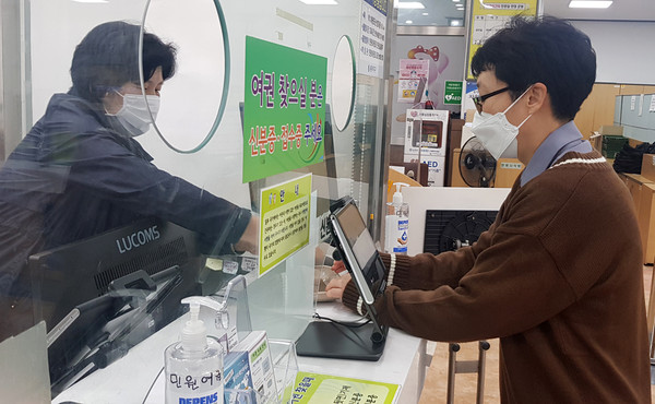 ▲ 민원인이 퇴근 후 여권을 교부받고 있는 모습.