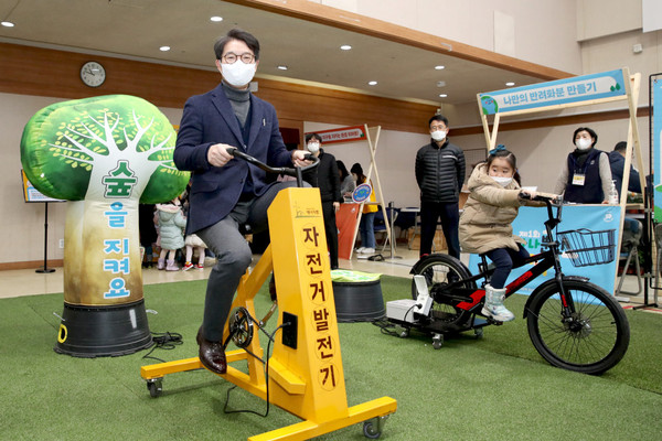 ▲ 지난해 개최된 제1회 하나뿐인 지구 행사에서 정원오 구청장이 자전거 발전기를 돌리고 있다.
