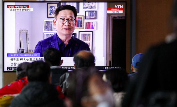 ▲ 서울 중구 서울역에서 시민들이 송영길 더불어민주단 전 대표의 2021년 전당대회 돈봉투 의혹 관련 뉴스를 시청하고 있다. /뉴시스