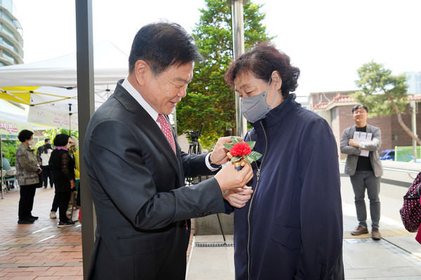 ▲이필형 동대문구청장(사진 왼쪽)이 시립동대문노인종합복지관의 어르신 감사 축제에 참석해 직접 카네이션을 달아드리고 있다.