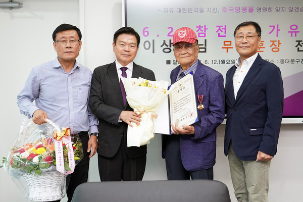 ▲ 이필형 동대문구청장(사진 왼쪽 두 번째)이 이상만 참전용사(사진 오른쪽 두 번째)에게 화랑무공훈장을 전수한 뒤 기념 촬영을 하고 있다.