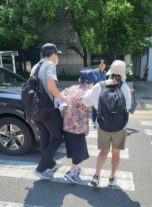 ▲ 두 의인이 어르신을 부축해 횡단보도를 건너는 모습.
