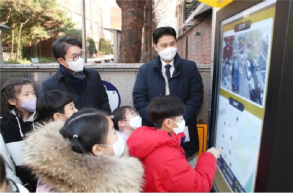 ▲ 스마트 안전통학로 조성사업으로 응봉초 정문에 설치한 반응형 키봇으로 통학로 인근 CCTV를 실시간 확인가능하다. 응봉초 아이들이 반응형 키봇을 조작하는 모습.