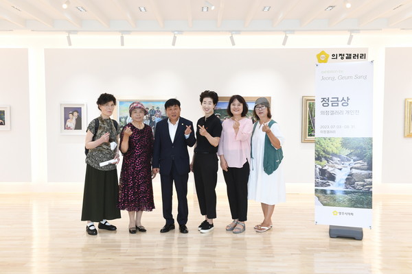 ▲ 윤창철 의장과 정금상 작가를 비롯한 한국미술협회 양주지부 소속 작가들이 작품을 배경으로 기념촬영을 하고 있다.