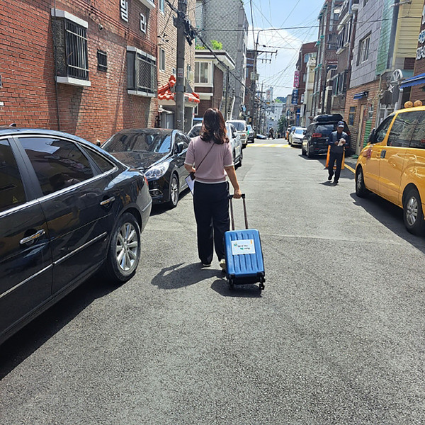 ▲ 성남시 해오름도서관 직원이 독서소외계층 아동에 빌려줄 책을 캐리어에 담아 배달 중이다.