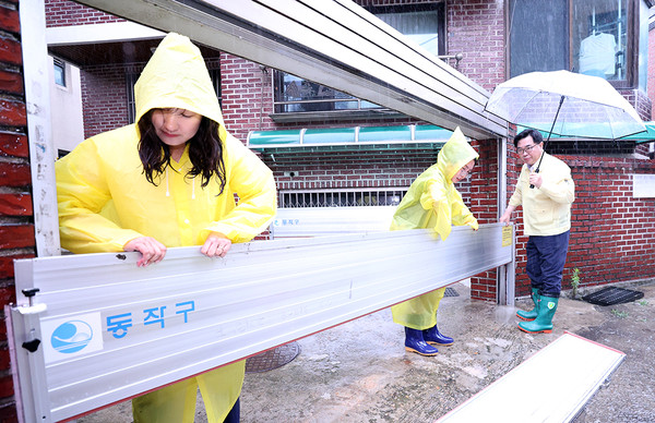 ▲ 박일하 동작구청장이 지난 11일 상도3동 성대시장 인근 가정 집에서 직원들과 차수판을 설치하고 있다.