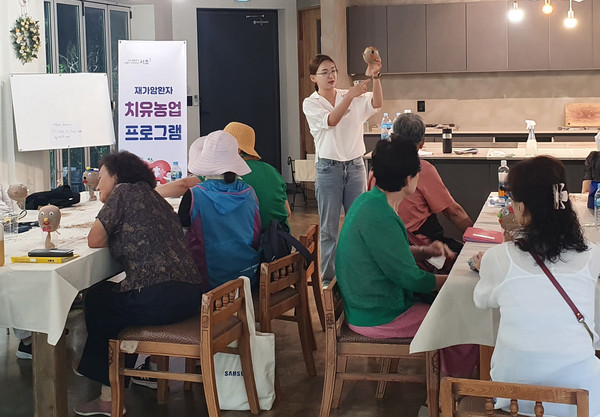 ▲ ‘재가 암환자 치유농업 프로그램’에서 참가자들이 ‘잔디인형 만들기’ 실습을 하고 있다.