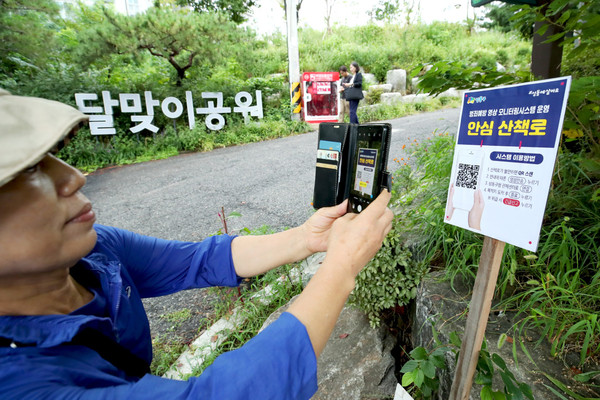 ▲ 성동구 달맞이 공원에서 산책로 범죄예방시스템을 이용하는 주민의 모습.