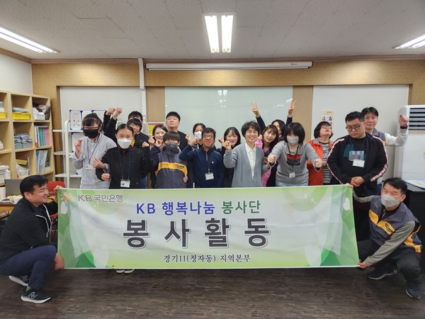 ▲ KB국민은행의 직원 및 가족이 봉사활동 관련 기념촬영을 하고 있다.