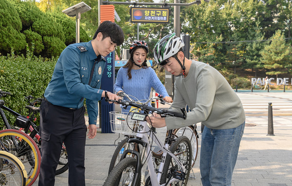 ▲ 양천구 '자전거 지킴이 솔루션' 적용을 위해 자전거를 등록한 후 '자전거 지킴이 존'에서 전자칩이 내장된 자전거 번호판을 장착중인 구민의 모습.