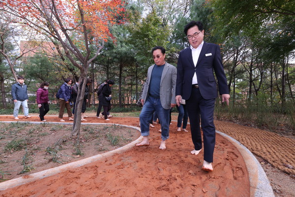▲ 지난 8일 오전 대방공원에서 맨발황토길 개방식을 개최하고 박일하 동작구청장이 주민 40여 명과 함께 황토길을 체험하고 있다.