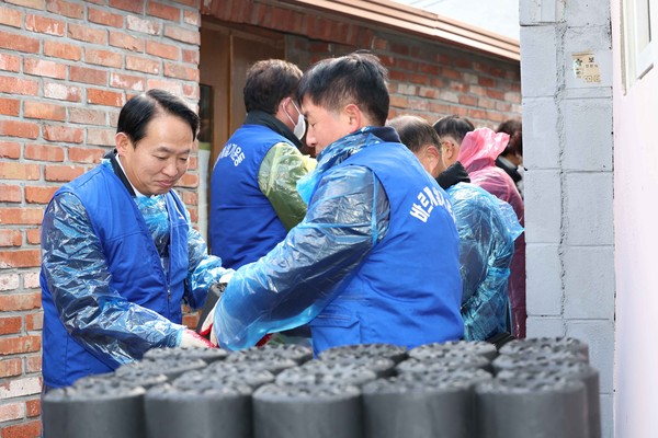 ▲ 김찬진 인천동구청장이 바르게살기운동 인천동구협의회 관계자들과 연탄을 나르고 있다.