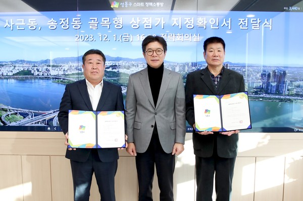 ▲ 골목형 상점가 지정확인서 전달식에서 사진을 촬영하고 있는 정원오 성동구청장(사진 가운데)과 유철상 사근살곶이 상점가 상인회장(사진 오른쪽), 정창영 송정벚꽃 상점가 상인회장(사진 왼쪽).