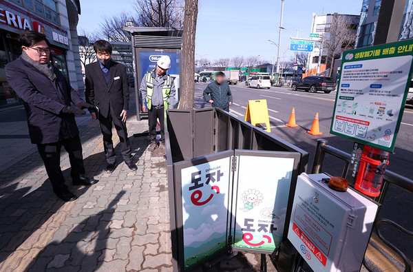 ▲ 박일하 동작구청장이 노량진역 5번 출구 앞에서 전국 최초로 설치된 ‘태양광 자동접이식 생활폐기물 수거함’의 작동 여부를 시범적으로 확인하고 있다.