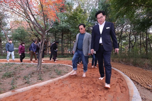 ▲ 대방공원에서 맨발황톳길 개방식에서 박일하 동작구청장(오른쪽)이 황톳길을 체험하고 있다.