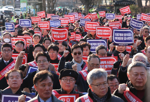 ▲ 지난달 25일 서울 대한의사협회에서 '의대 정원 증원 저지를 위한 전국 의사 대표자 확대회의'를 마치고 대통령실 앞으로 행진해 온 대한의사협회 비상대책위원회와 전국 의사 대표들이 구호를 외치고 있다. /뉴시스