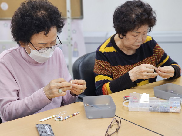 ▲ 성북구치매안심센터 정상군 어르신들이 ‘비즈 공예 프로그램’에서 키링을 만들고 있다.