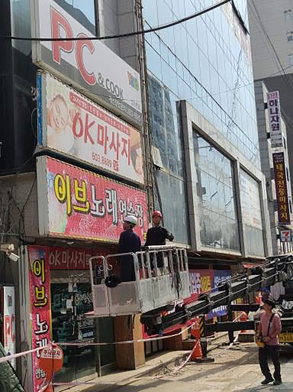 ▲ 성남시 관계자들이 중원구 한 건물의 주인없는 간판을 정비하고 있다.