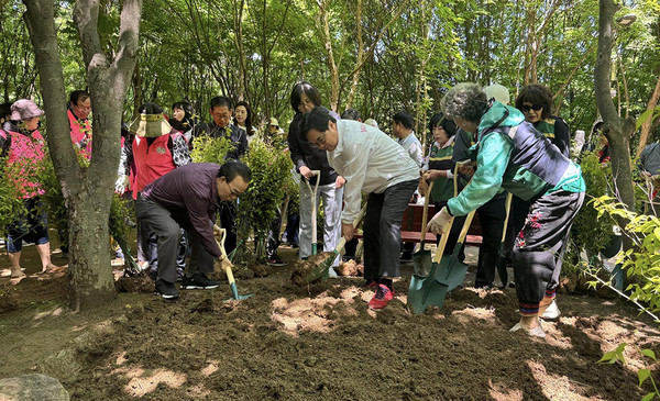 ▲ 박일하 동작구청장(가운데)이 서달산 등산로 내에서 열린 '맨발의 동작' 프로젝트 행사에서 주민들과 흙길 일대를 정비하고 있다.
