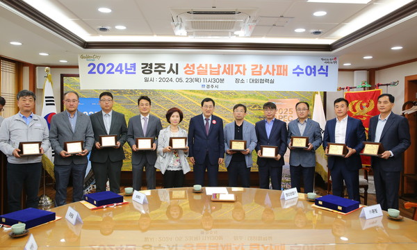 ▲ 주낙영 경주시장이 23일 청사 내 대외협력실에서 건전 납세 풍토 조성에 기여한 지방재정확충기여자 10명에게 감사패를 전달한 후 기념촬영을 하고 있다.