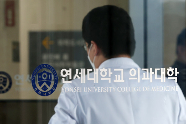 ▲ 세브란스 병원 의료진이 18일 오후 연세대 의대 교수협의회 비상대책위원회 주최로 연세 의대 임시 전체 교수 회의가 열리는 서울 서대문구 연세대 의과대학으로 들어서고 있다. /뉴시스