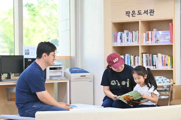 ▲ 하남시청 민원실을 방문한 한 시민이 대기하는 동안 책을 읽을 수 있는 민원실 내 ‘작은 도서관’에서 아이와 함께 책을 읽고 있다.